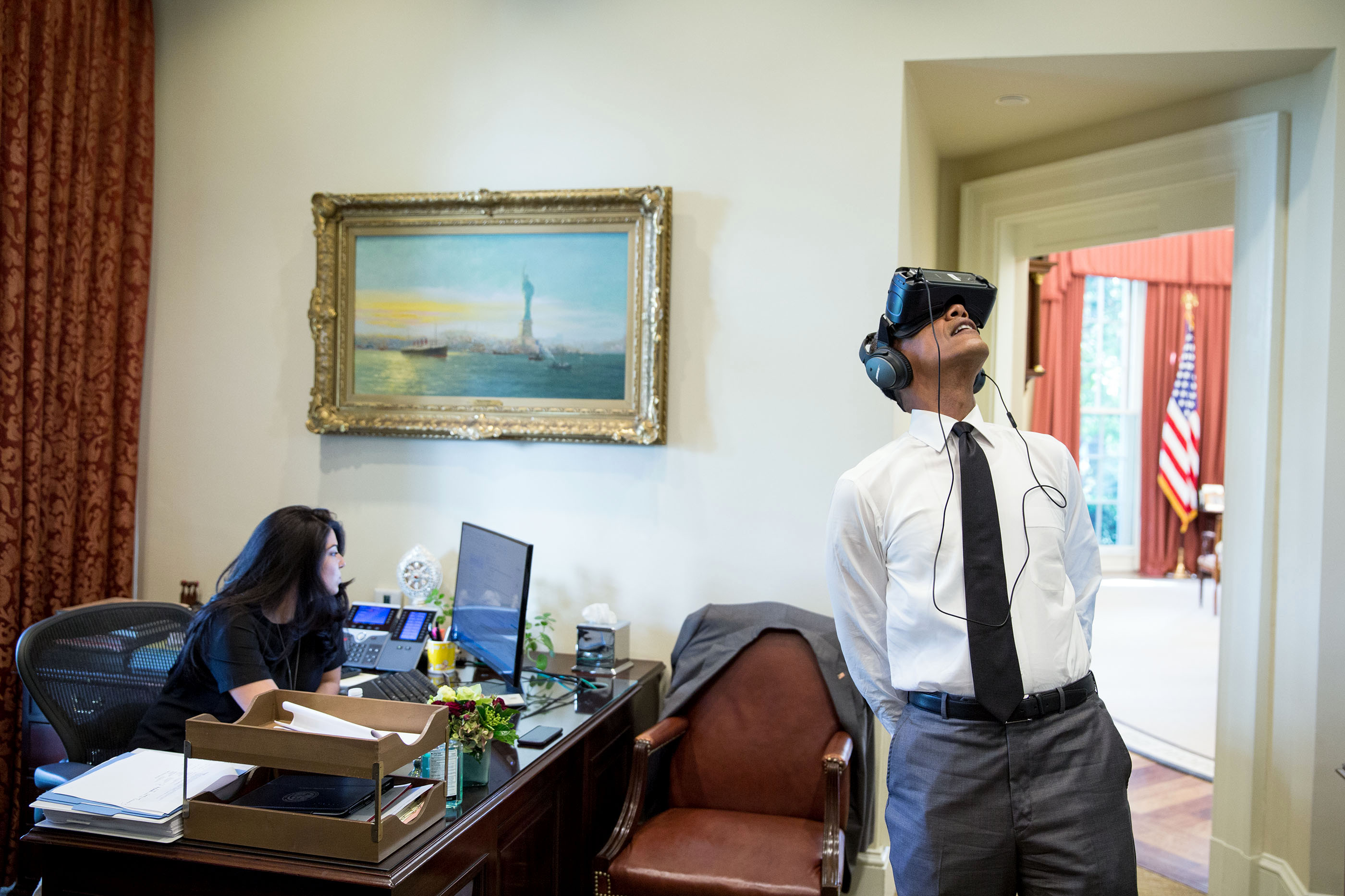 President Barack Obama watches a virtual reality film captured during his trip to Yosemite National Park earlier this year, in the Outer Oval Office, Aug. 24, 2016. Personal aide Ferial Govashiri sits at her desk at left. (Official White House Photo by Pete Souza)