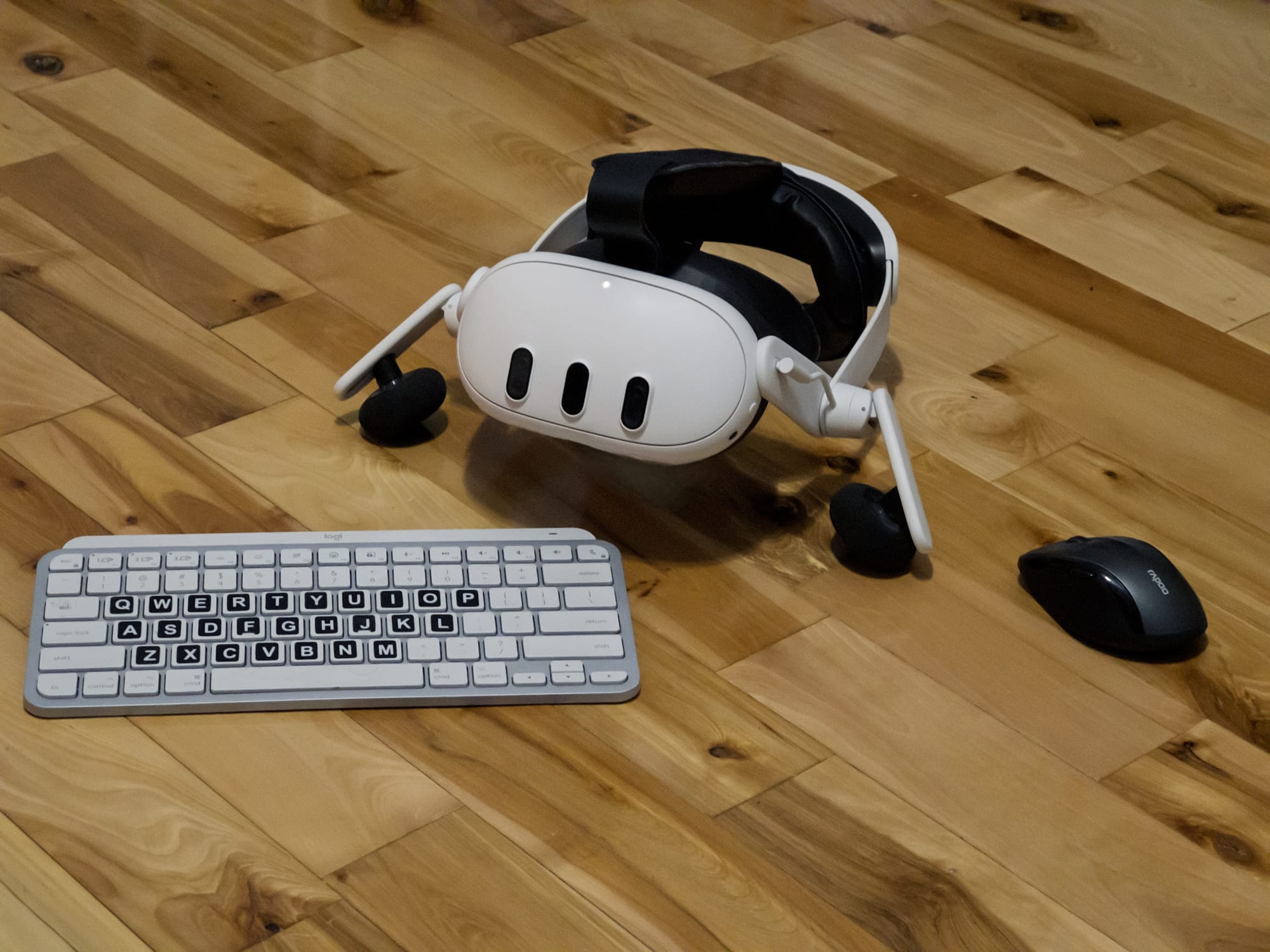 A Meta Quest 3 appears between a Bluetooth keyboard and mouse.